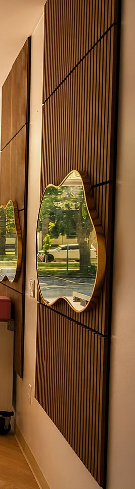 Close-up of wood acoustic slat panels and a gold-framed mirror