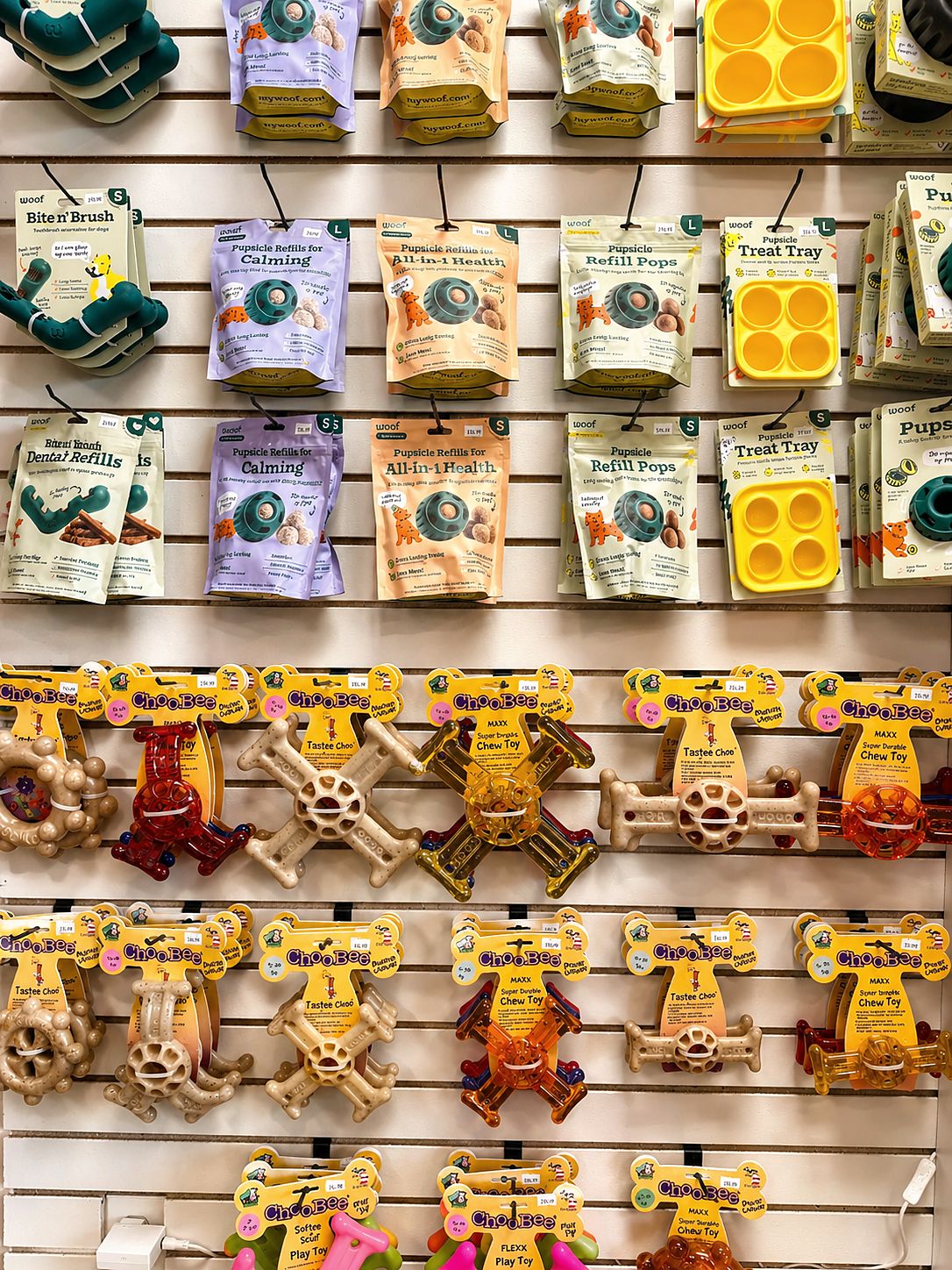 A wall of chew toys and treat refills in the PawSnickety Commerce Township boutique