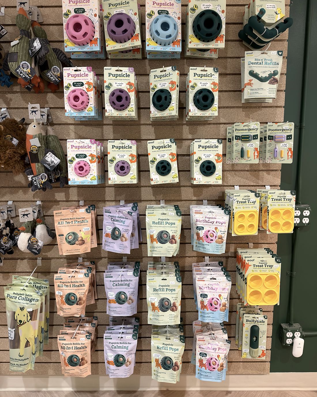 A wall of enrichment toys and treat refills in the PawSnickety East Lansing boutique